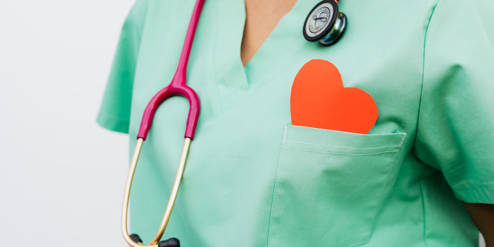 A healthcare professional with a stethoscope and red heart symbol.